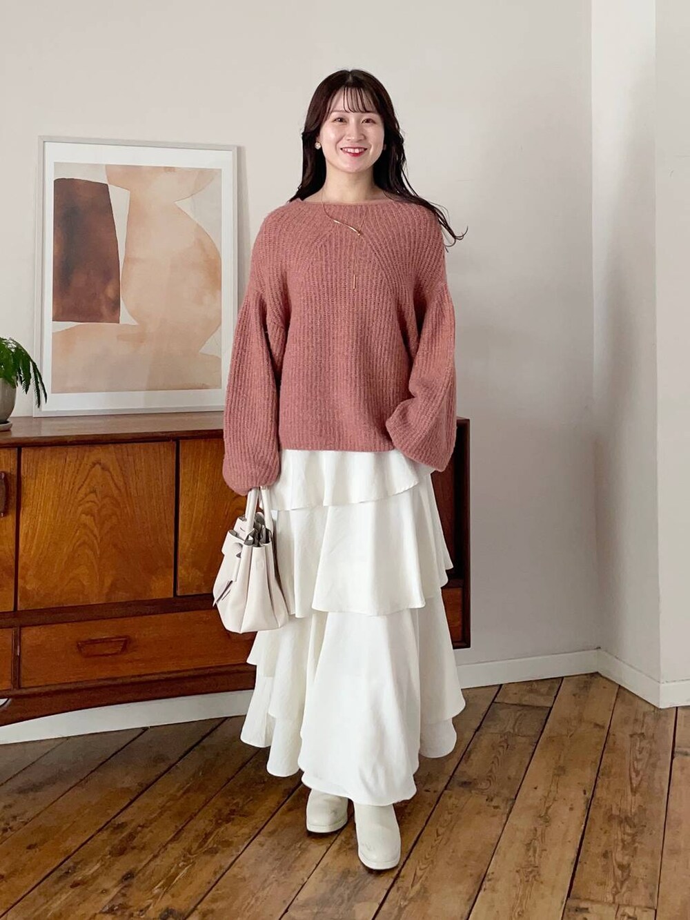 ホワイト系のチェスターコート、ホワイト系のブーツ、ホワイト系のスカートを着用したレディースの冬コーディネートの3枚目の写真