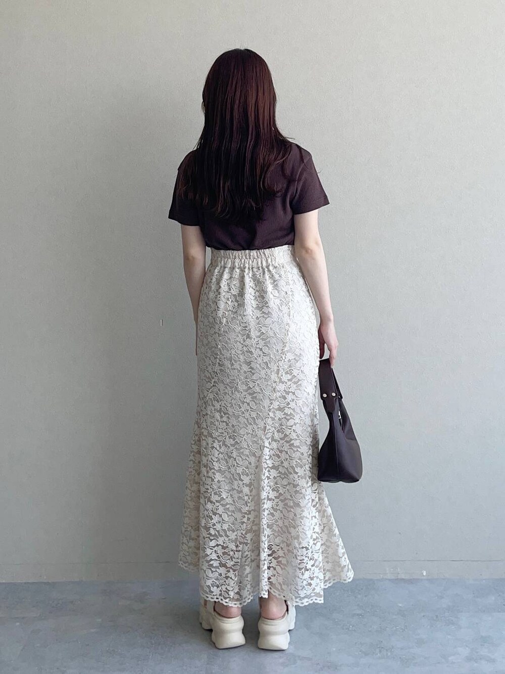 ホワイト系のサンダル、ブラウン系のショルダーバッグ、ベージュ系のスカートを着用したレディースの夏コーディネートの2枚目の写真