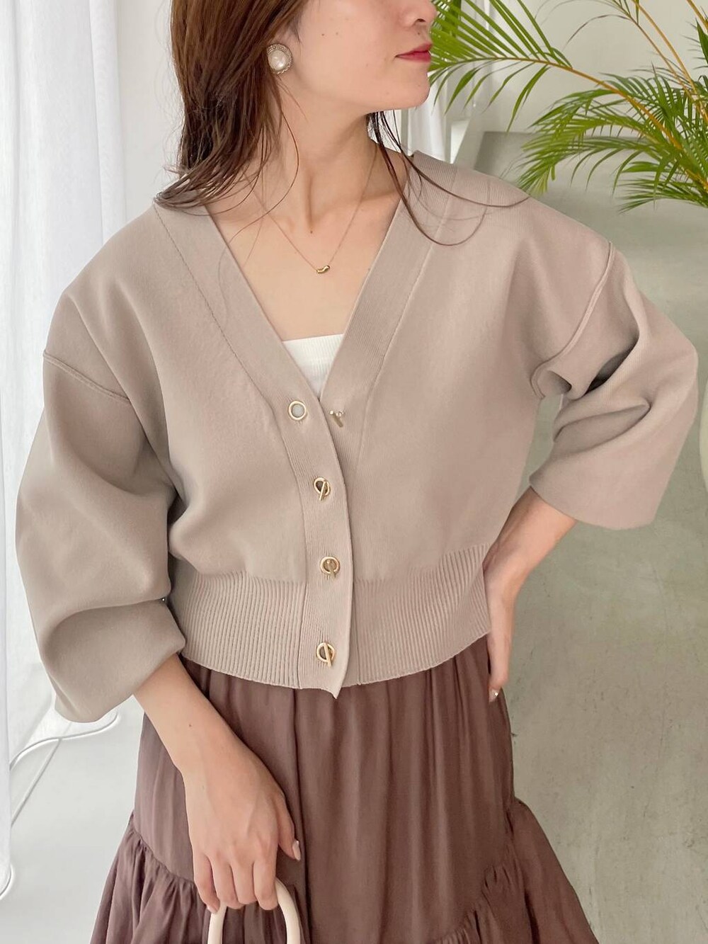 ホワイト系のハンドバッグ、グレー系のブーツ、ベージュ系のカーディガン/ボレロを着用したレディースの秋コーディネートの3枚目の写真