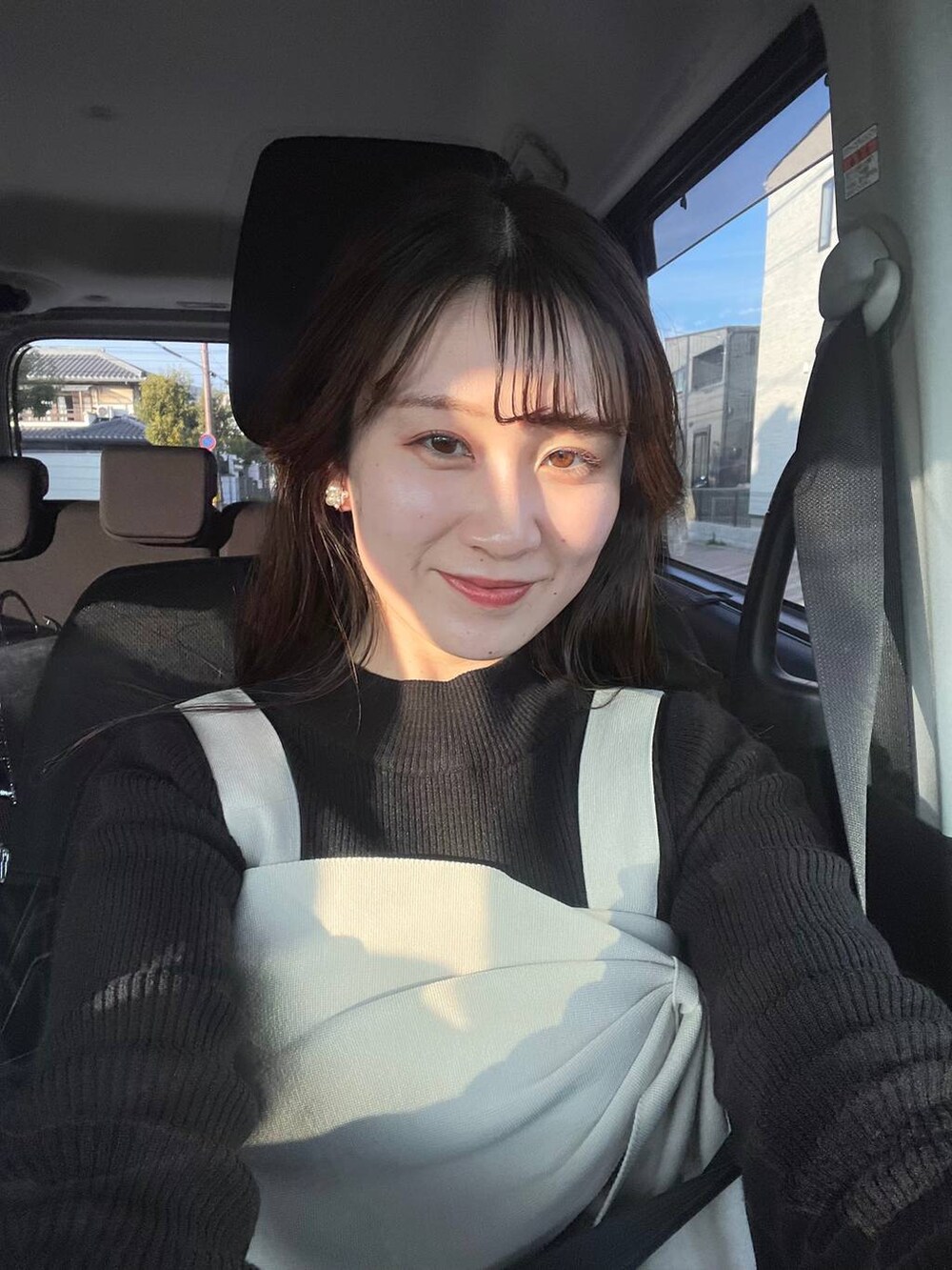 ブラック系のニット/セーター、ブラック系のスカート、ホワイト系のトートバッグを着用したレディースの冬コーディネートの4枚目の写真