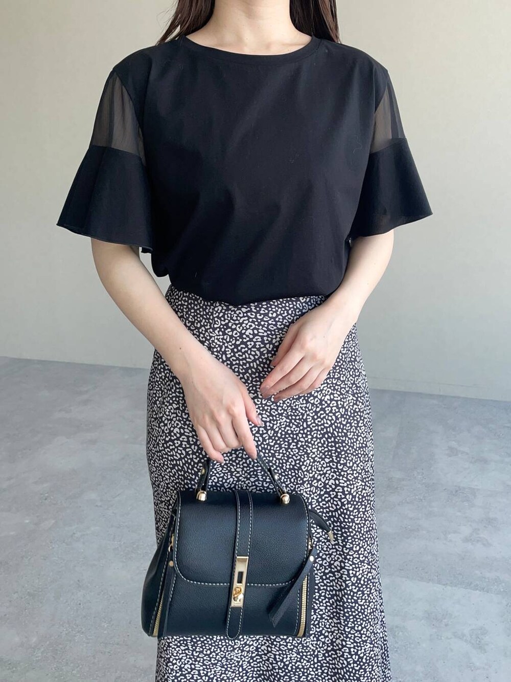 ブラック系のTシャツ/カットソー、ブラック系のスカート、ブラック系のパンプスを着用したレディースの夏コーディネートの3枚目の写真