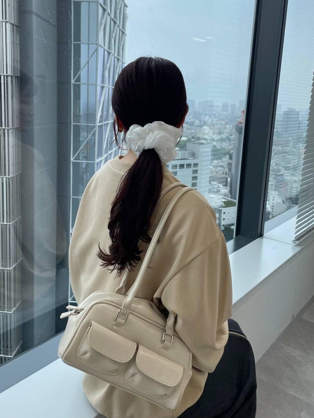 ホワイト系のブーツ、グレー系のスカート、ベージュ系のスウェットを着用したレディースの秋コーディネートの3枚目の写真