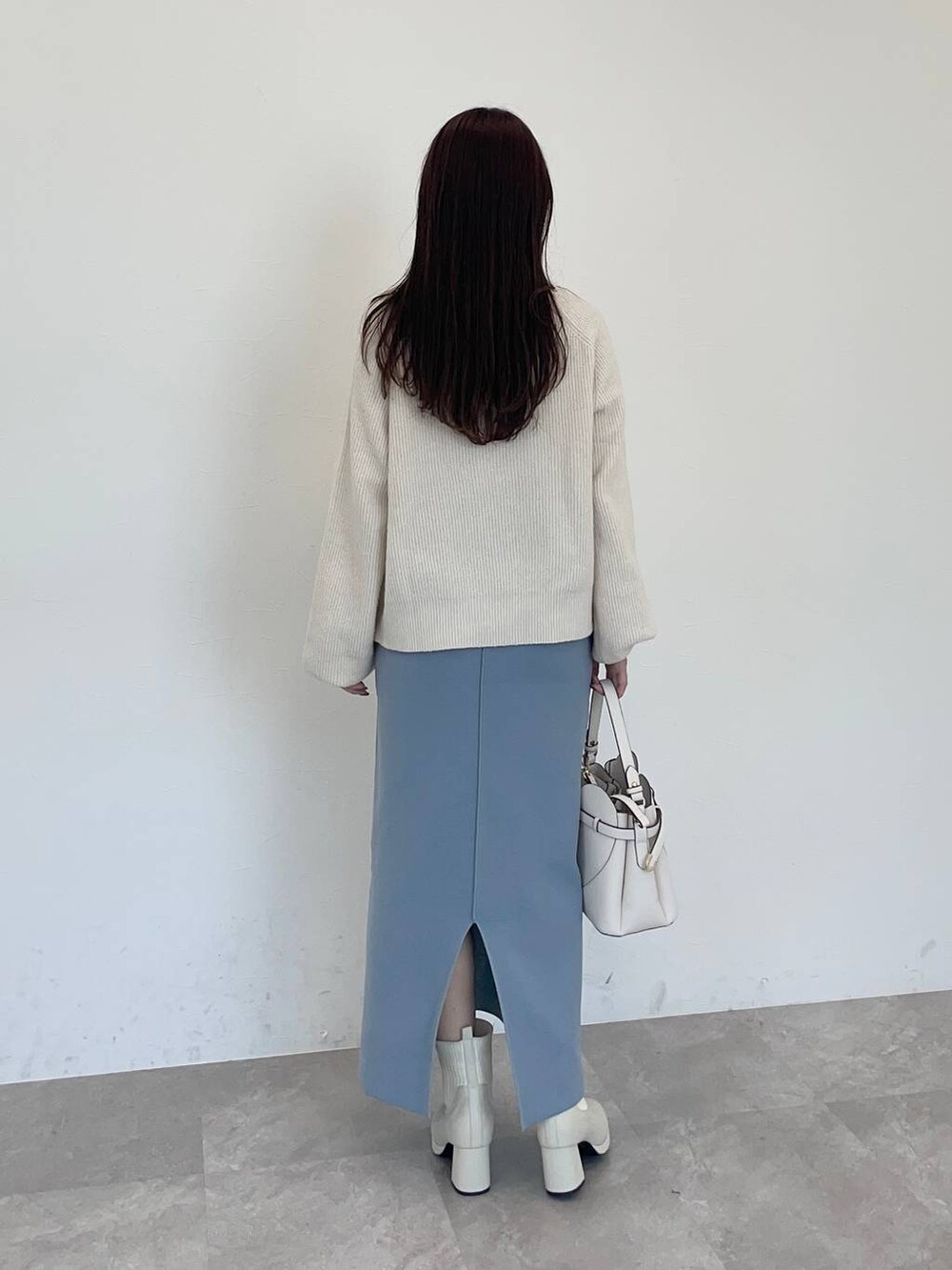 ホワイト系のショルダーバッグ、ホワイト系のブーツ、ホワイト系のニット/セーターを着用したレディースの秋コーディネートの2枚目の写真