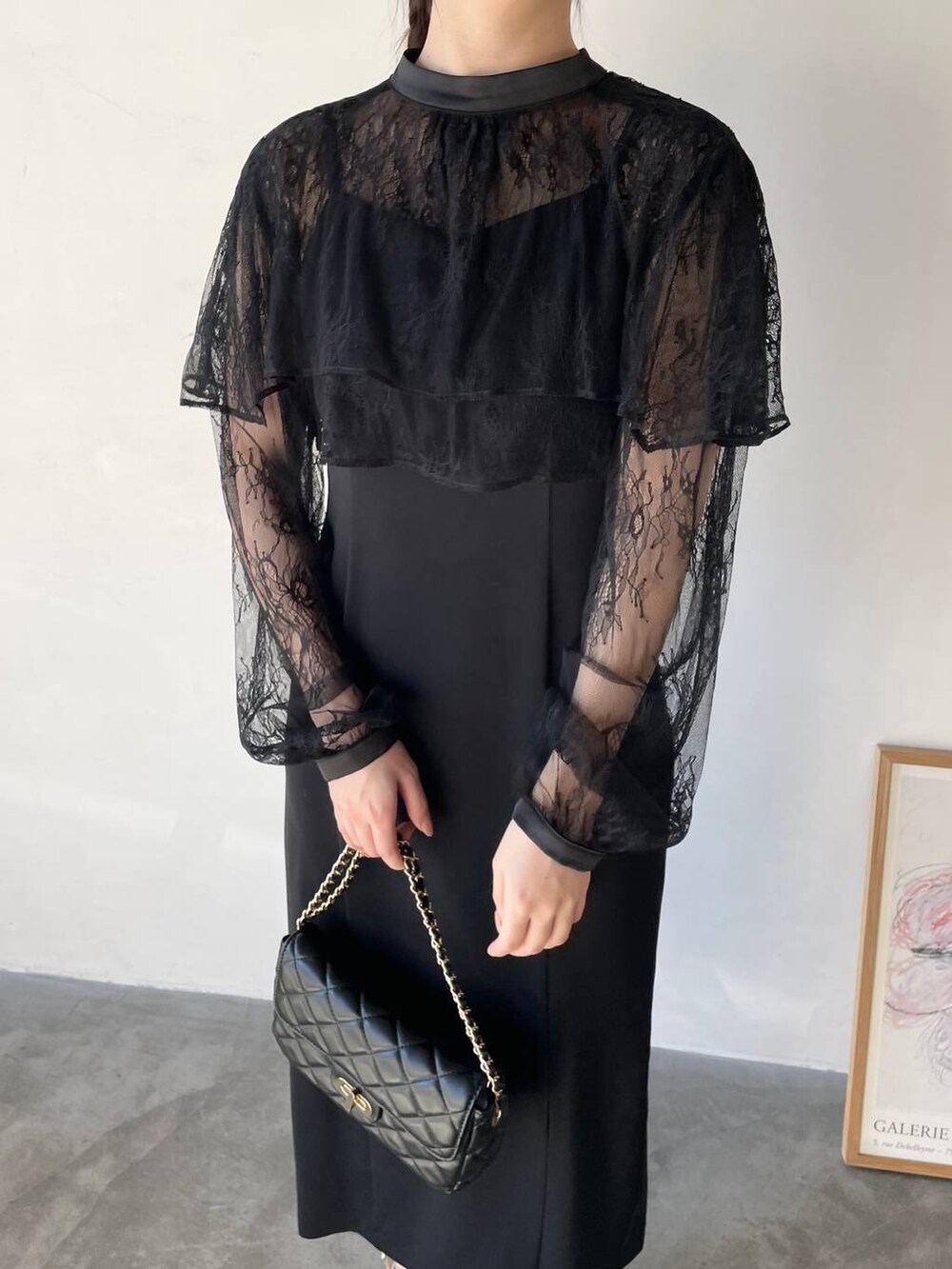 ブラック系のドレス、ブラック系のショルダーバッグ、ベージュ系のパンプスを着用したレディースの冬コーディネートの3枚目の写真