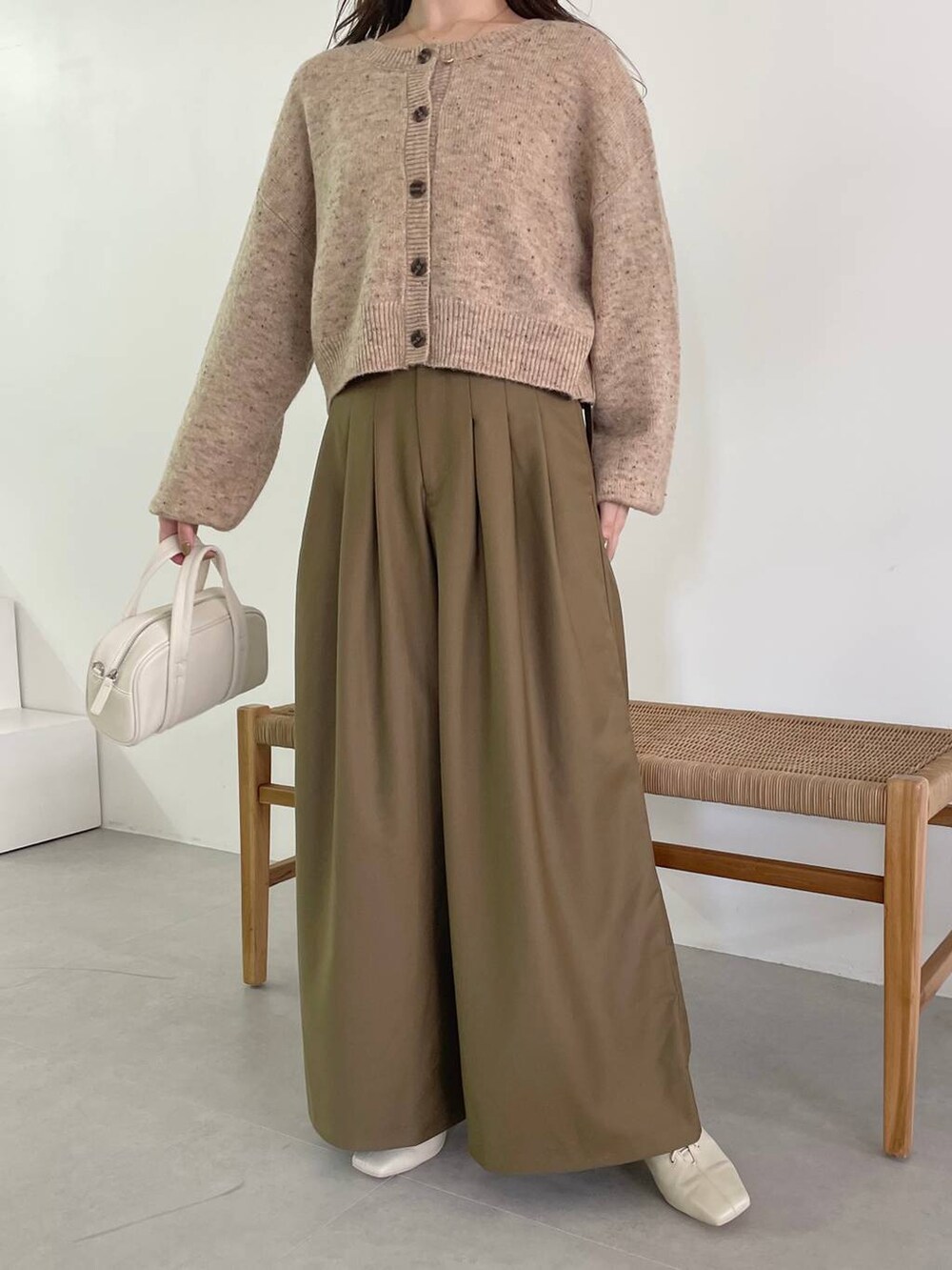 ホワイト系のボストンバッグ、ホワイト系のブーツ、ベージュ系のカーディガン/ボレロを着用したレディースの秋コーディネートの4枚目の写真