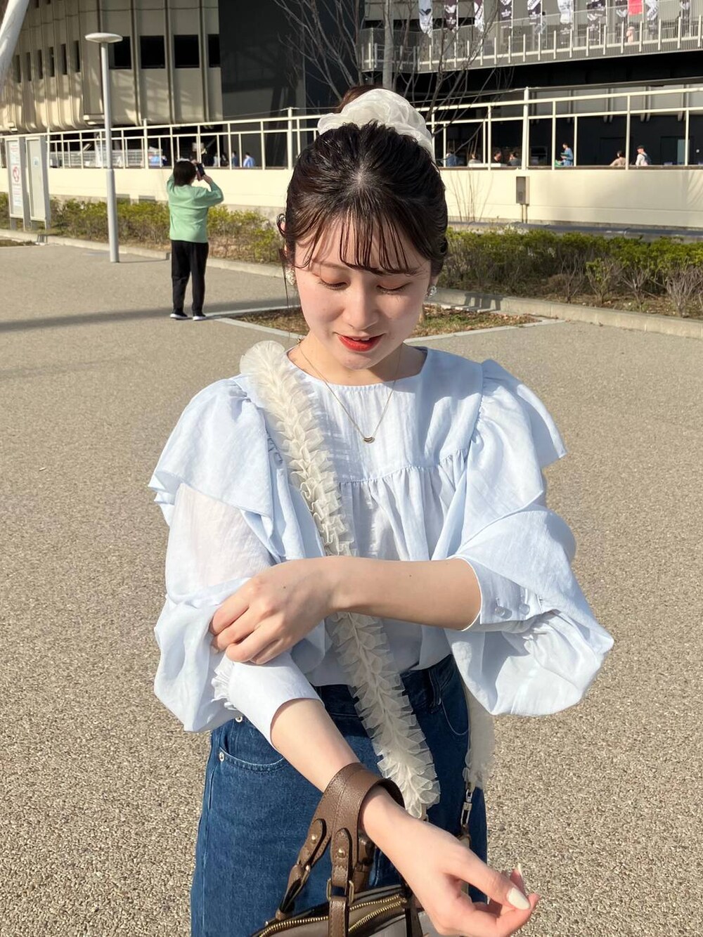 ブルー系のシャツ/ブラウス、ホワイト系のトートバッグ、その他のスマホケース/カバーを着用したレディースの春コーディネートの4枚目の写真