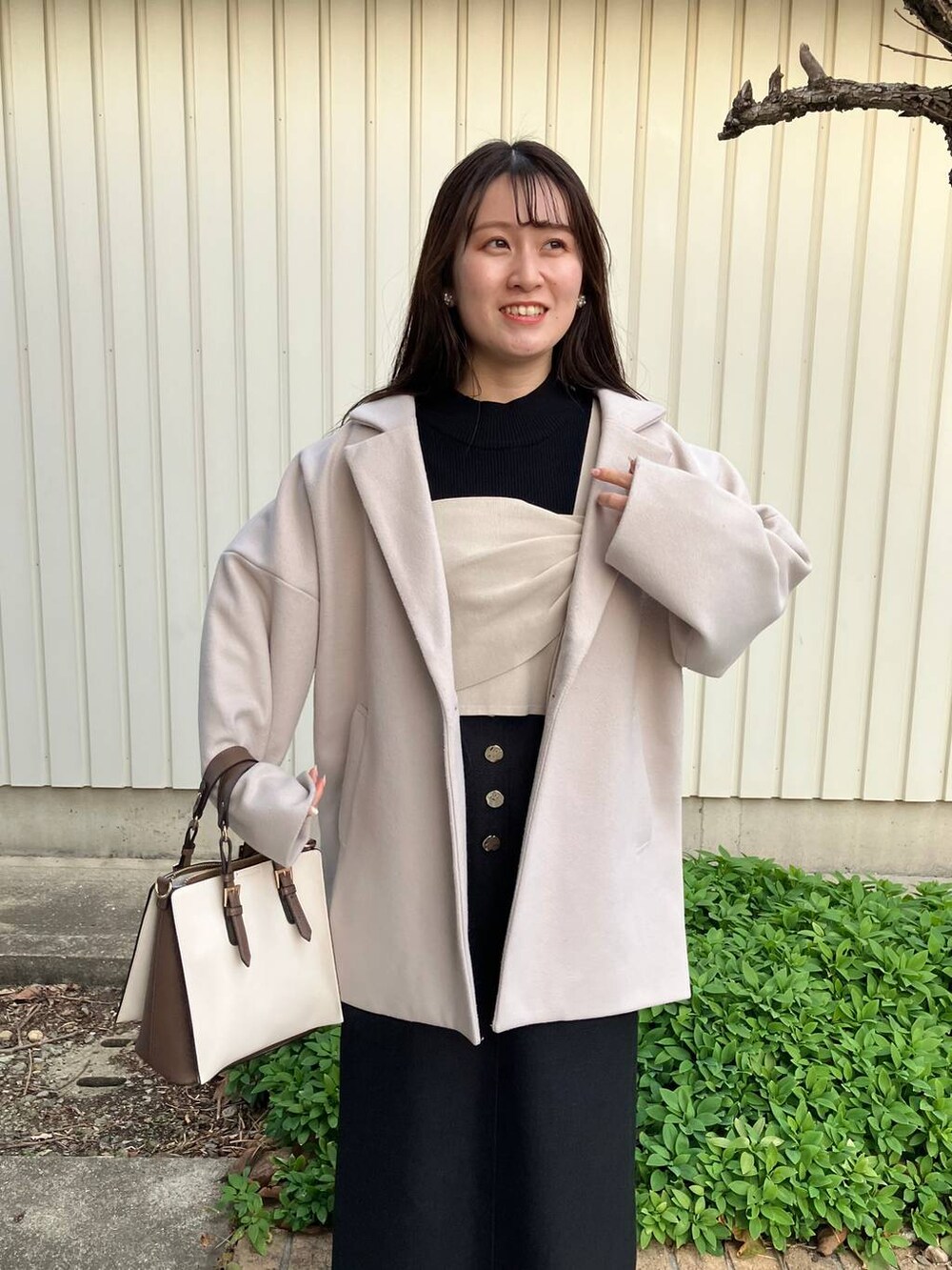 ブラック系のニット/セーター、ブラック系のスカート、ホワイト系のトートバッグを着用したレディースの冬コーディネートの3枚目の写真