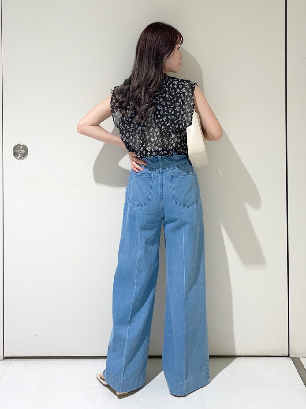 ブラック系のシャツ/ブラウス、ブルー系のデニムパンツ、ホワイト系のハンドバッグを着用したレディースの夏コーディネートの2枚目の写真