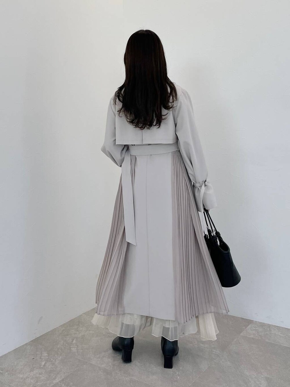 ベージュ系のワンピース、ブラック系のハンドバッグ、ブラック系のブーツを着用したレディースの冬コーディネートの2枚目の写真