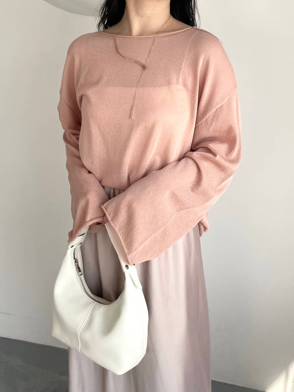 ピンク系のニット/セーター、シルバー系のバレエシューズ、ホワイト系のキャミソールを着用したレディースの春コーディネートの3枚目の写真