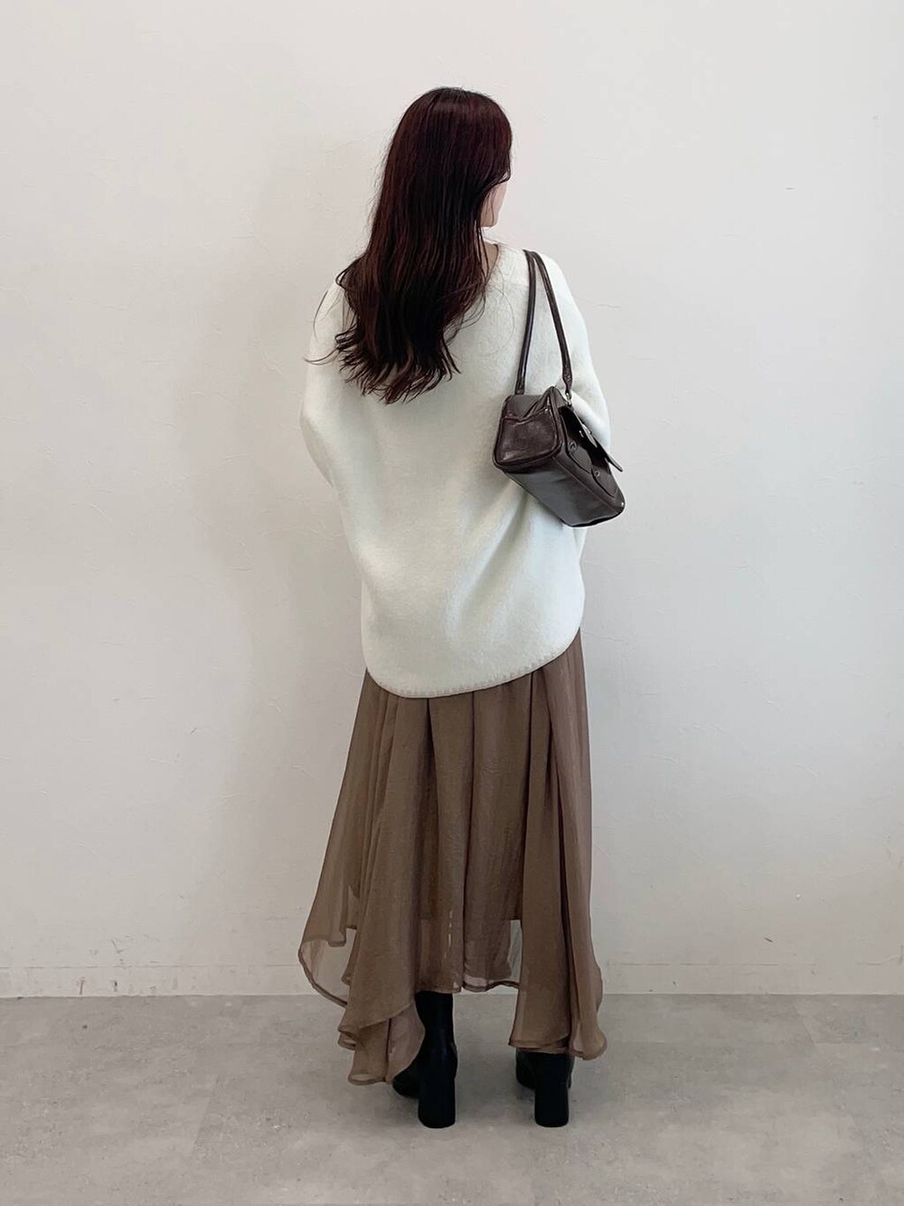 ブラック系のブーツ、ブラウン系のハンドバッグ、ホワイト系のブルゾンを着用したレディースの秋コーディネートの5枚目の写真