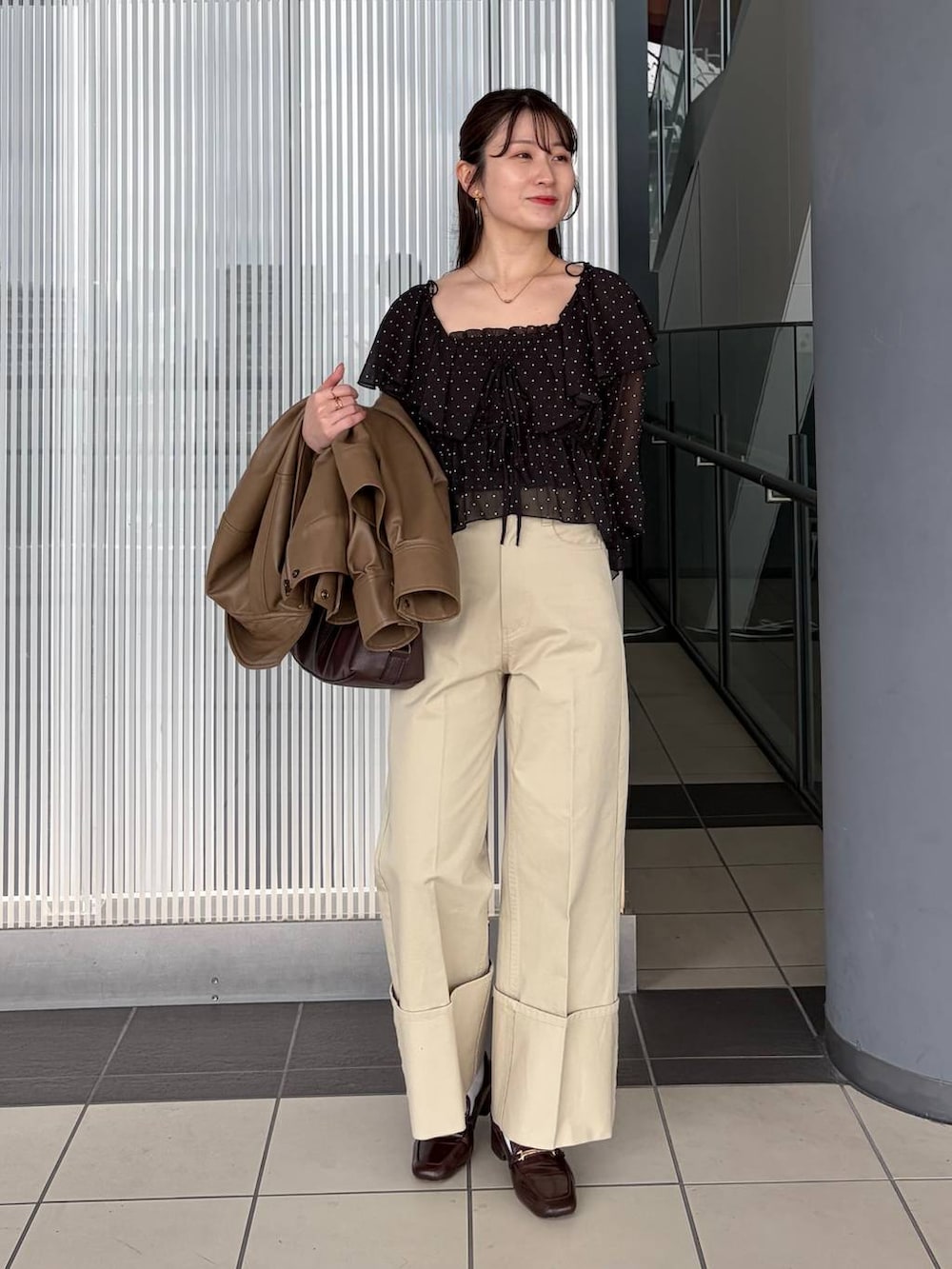 ブラウン系のボストンバッグ、ブラウン系のブルゾン、ブラック系のシャツ/ブラウスを着用したレディースの春コーディネートの3枚目の写真