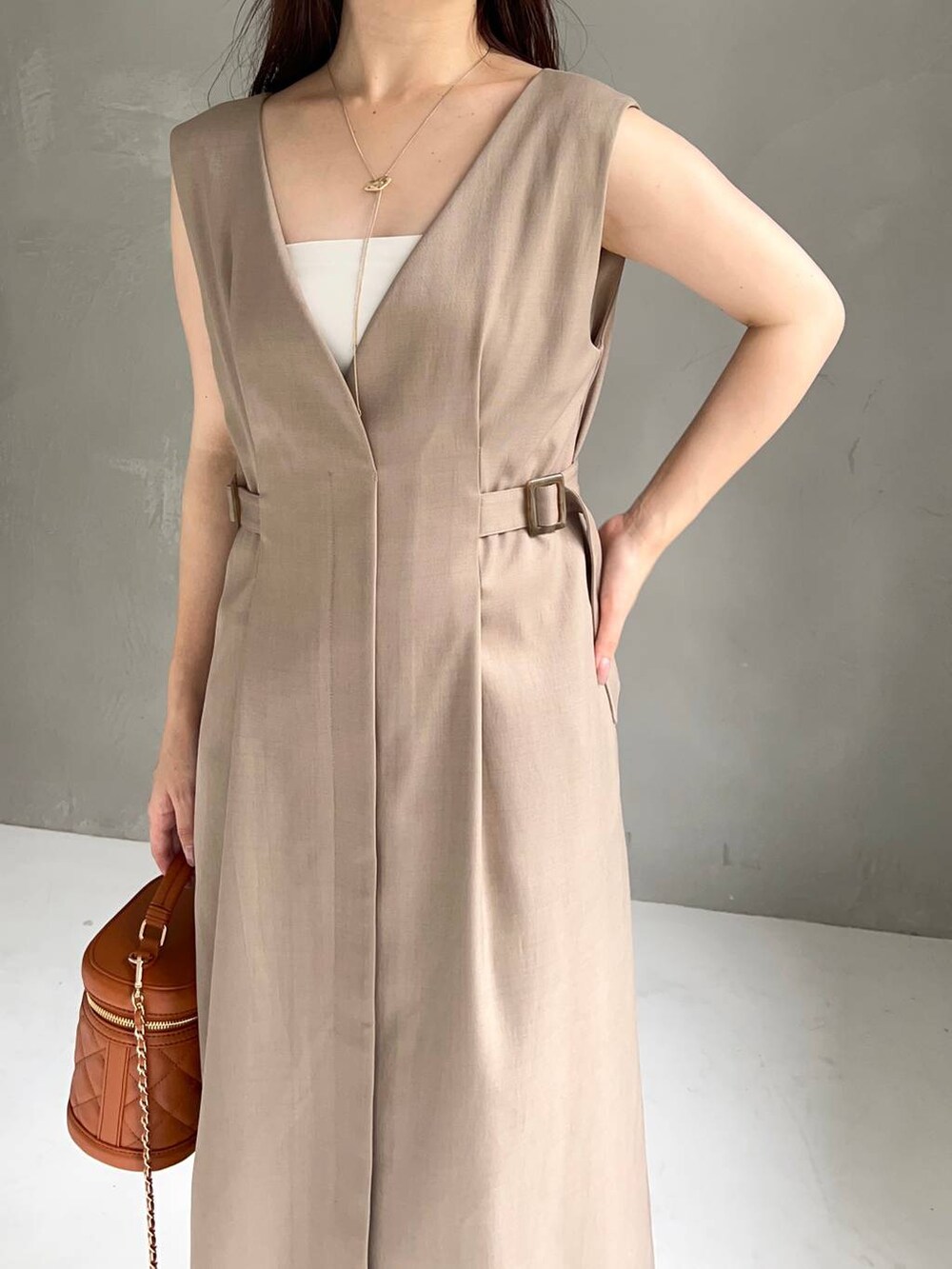 ホワイト系のサンダル、ベージュ系のジャンパースカートを着用したレディースの夏コーディネートの4枚目の写真