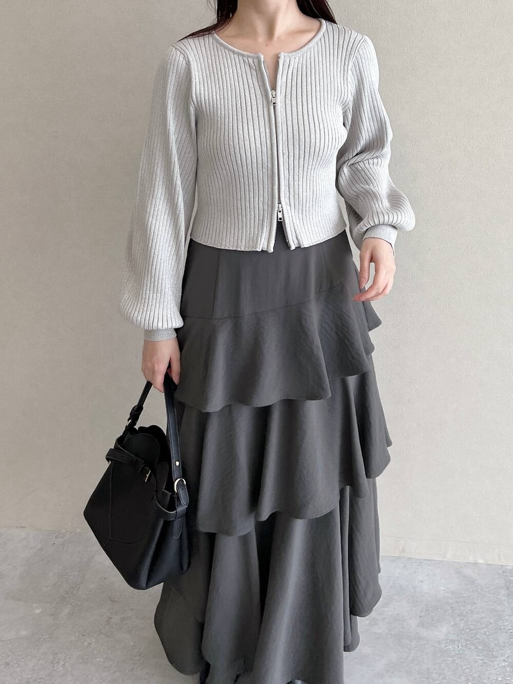 ブラック系のショルダーバッグ、ブラック系のブーツ、グレー系のカーディガン/ボレロを着用したレディースの秋コーディネートの3枚目の写真