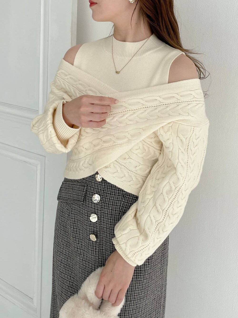 ホワイト系のブーツ、ホワイト系のハンドバッグ、ブラック系のスカートを着用したレディースの秋コーディネートの3枚目の写真