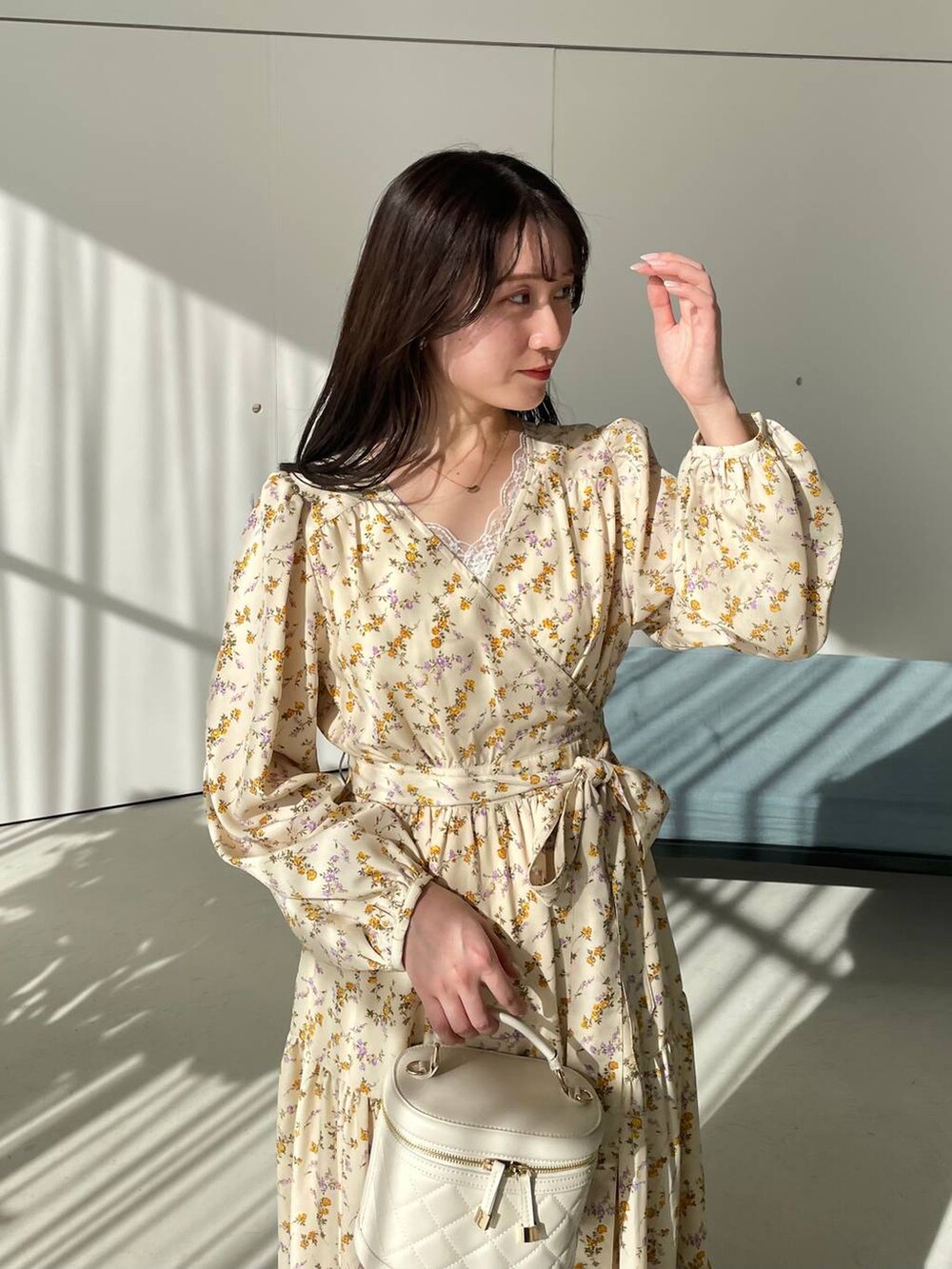 ホワイト系のタンクトップ、ホワイト系のショルダーバッグ、ベージュ系のパンプスを着用したレディースの冬コーディネートの6枚目の写真