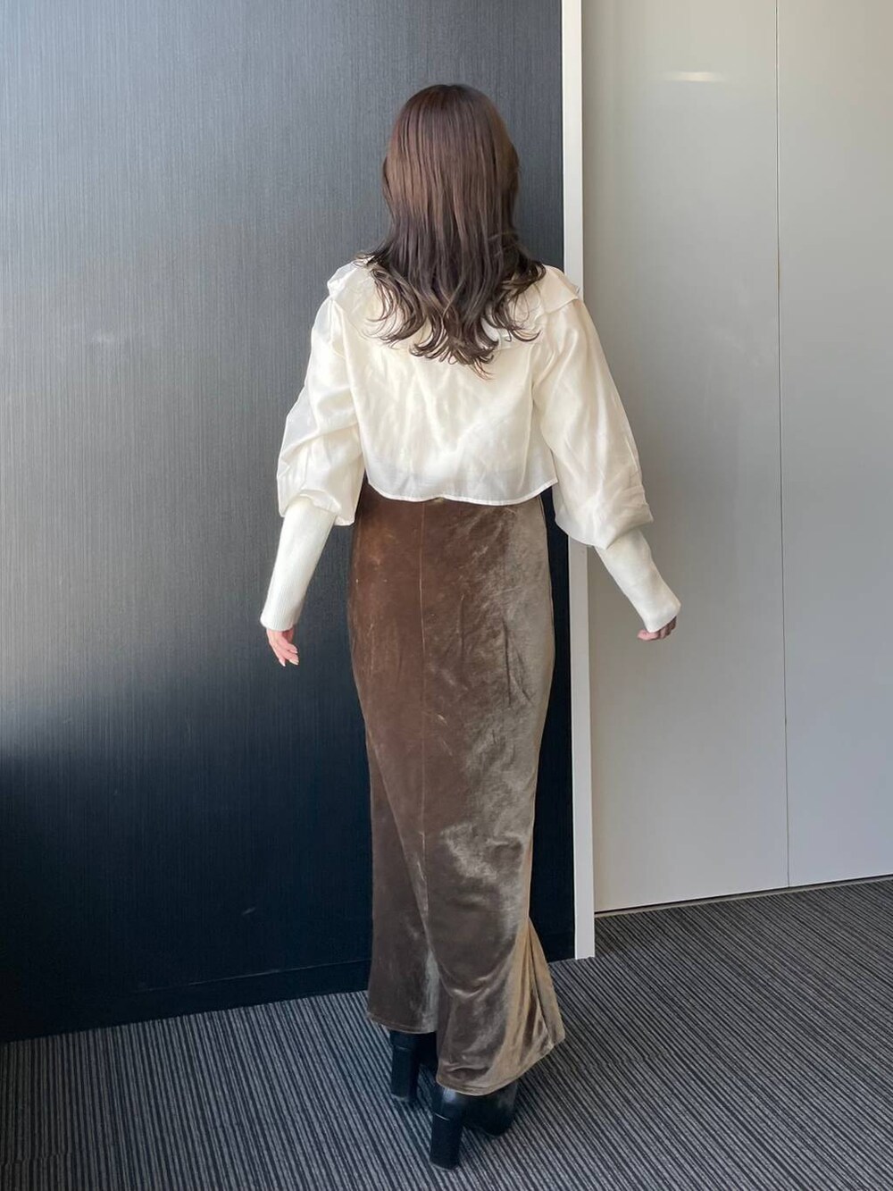 ブラウン系のスカート、ホワイト系のシャツ/ブラウス、ゴールド系のネックレスを着用したレディースの秋コーディネートの2枚目の写真