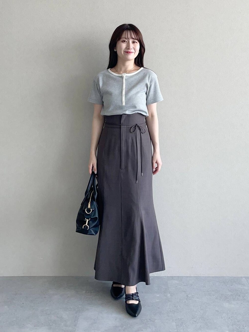 ブラウン系のテーラードジャケット、ブラック系のパンプス、ブラック系のボストンバッグを着用したレディースの春コーディネートの3枚目の写真