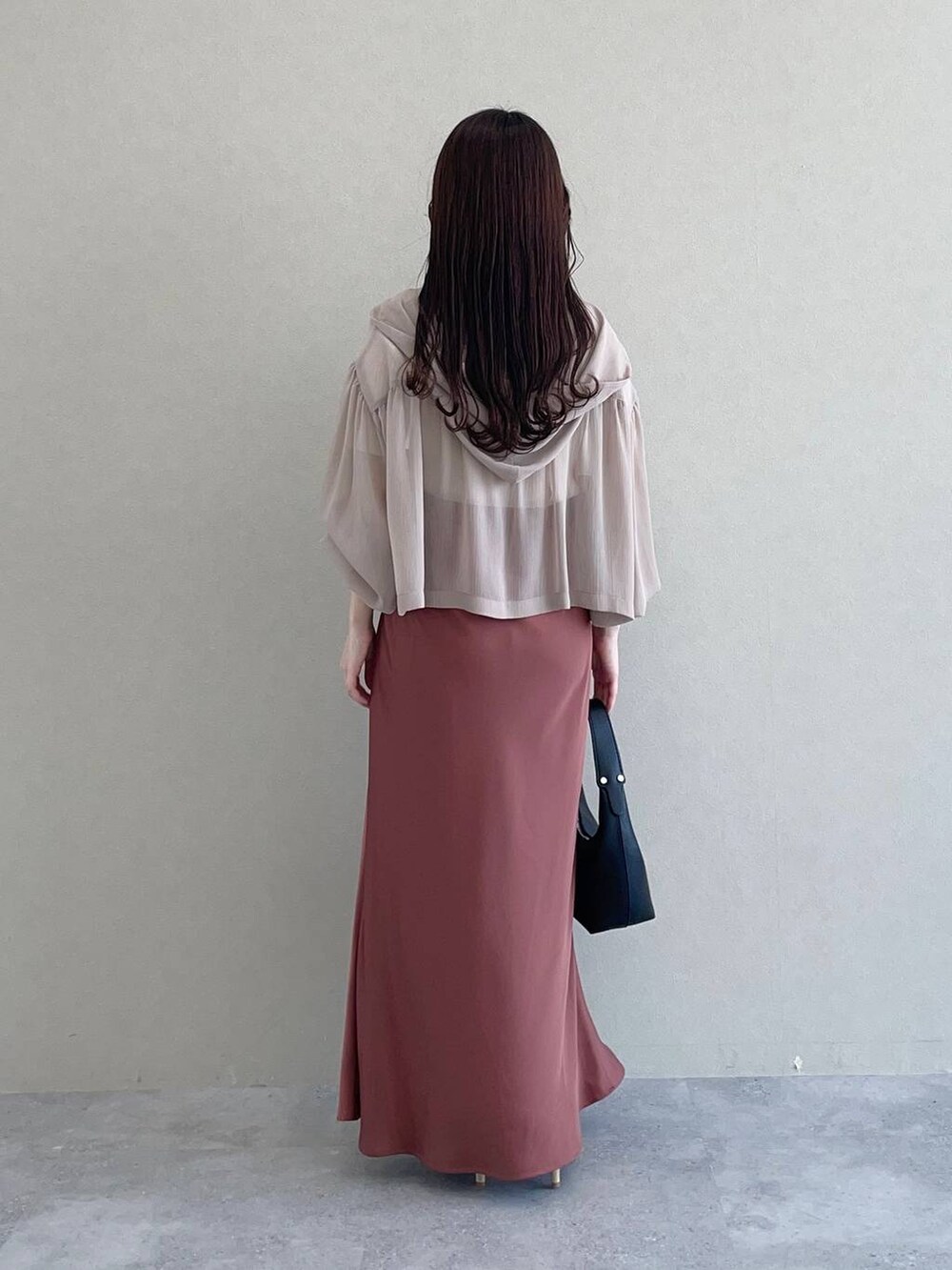 ベージュ系のパーカー、ブラック系のショルダーバッグ、ブラウン系のスカートを着用したレディースの春コーディネートの2枚目の写真