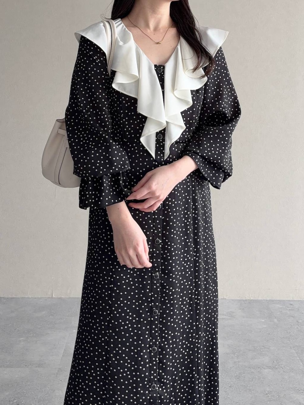 ブラック系のパンプス、ブラック系のワンピースを着用したレディースの春コーディネートの3枚目の写真