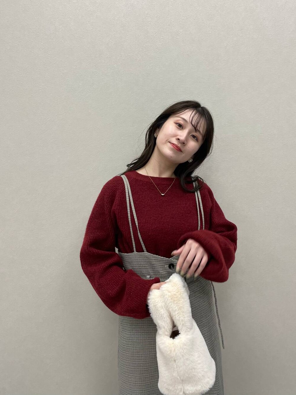 レッド系のニット/セーター、ホワイト系のブーツ、その他のスカートを着用したレディースの秋コーディネートの4枚目の写真