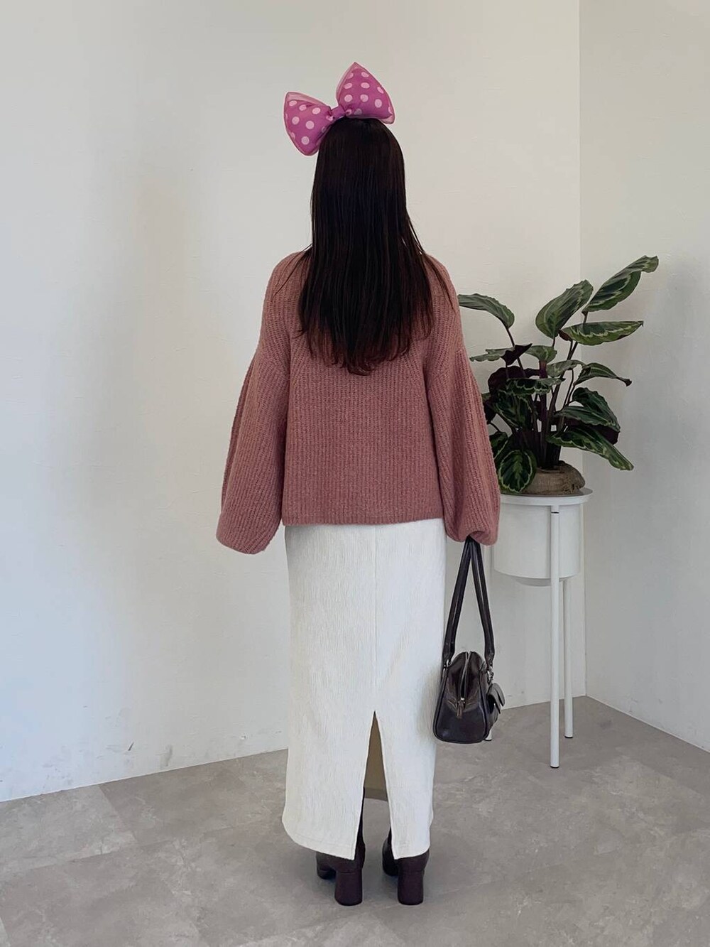 ブラウン系のブーツ、ホワイト系のスカート、ピンク系のニット/セーターを着用したレディースの冬コーディネートの4枚目の写真