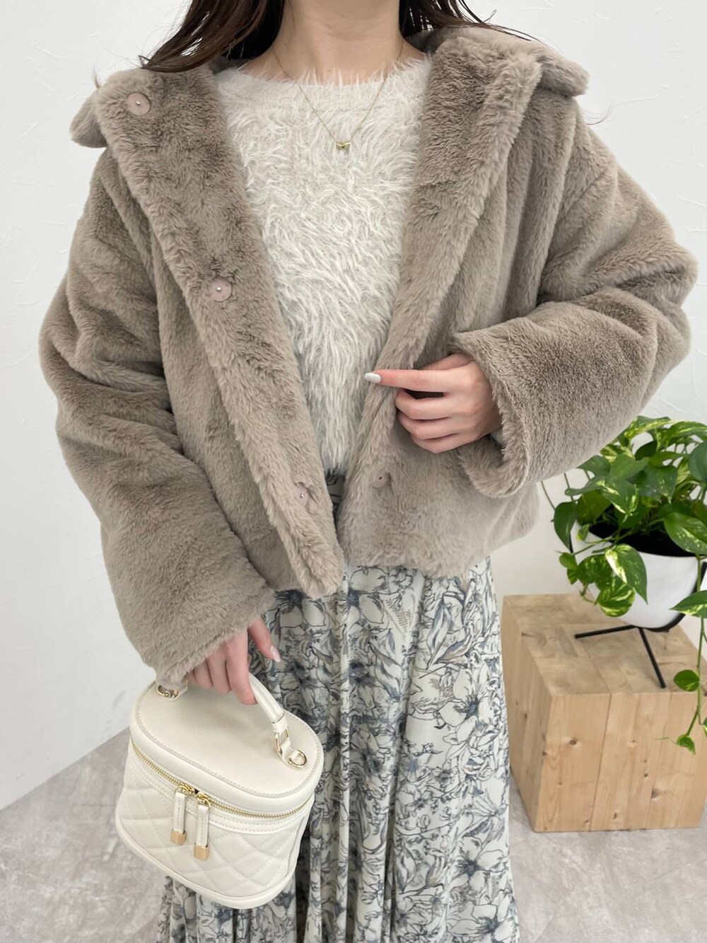 ホワイト系のブーツ、ベージュ系のスカート、ホワイト系のショルダーバッグを着用したレディースの冬コーディネートの3枚目の写真