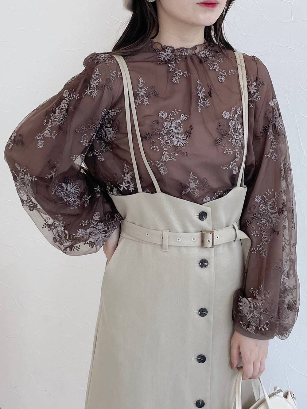 ホワイト系のボストンバッグ、ホワイト系のブーツ、ベージュ系のスカートを着用したレディースの夏コーディネートの3枚目の写真