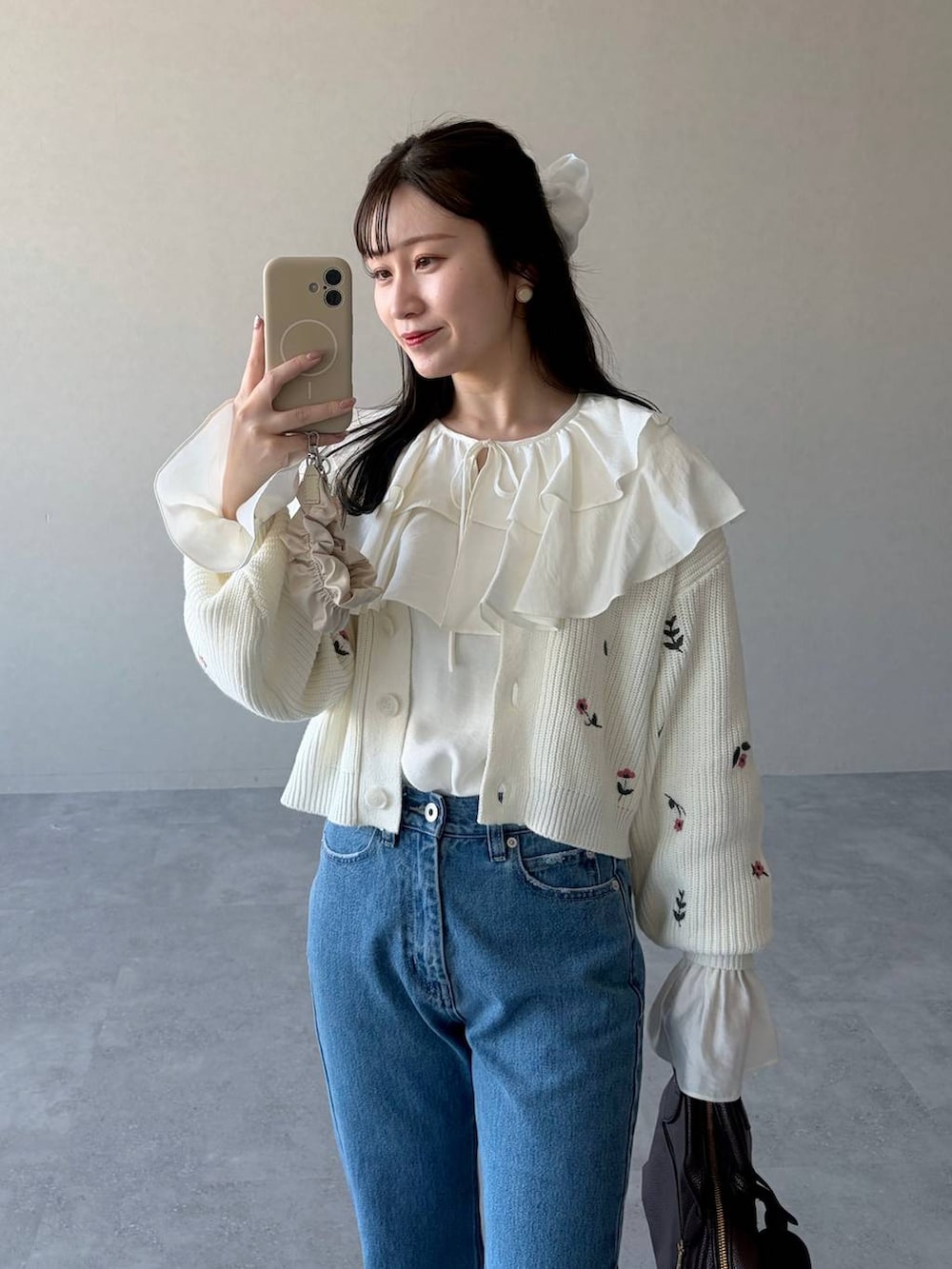 ブラウン系のボストンバッグ、ブルー系のデニムパンツ、ホワイト系のシャツ/ブラウスを着用したレディースの冬コーディネートの3枚目の写真