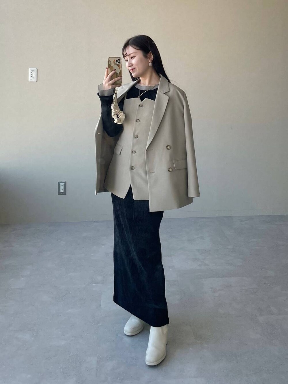 ホワイト系のブーツ、ブラック系のスカート、ホワイト系のショルダーバッグを着用したレディースの冬コーディネートの3枚目の写真