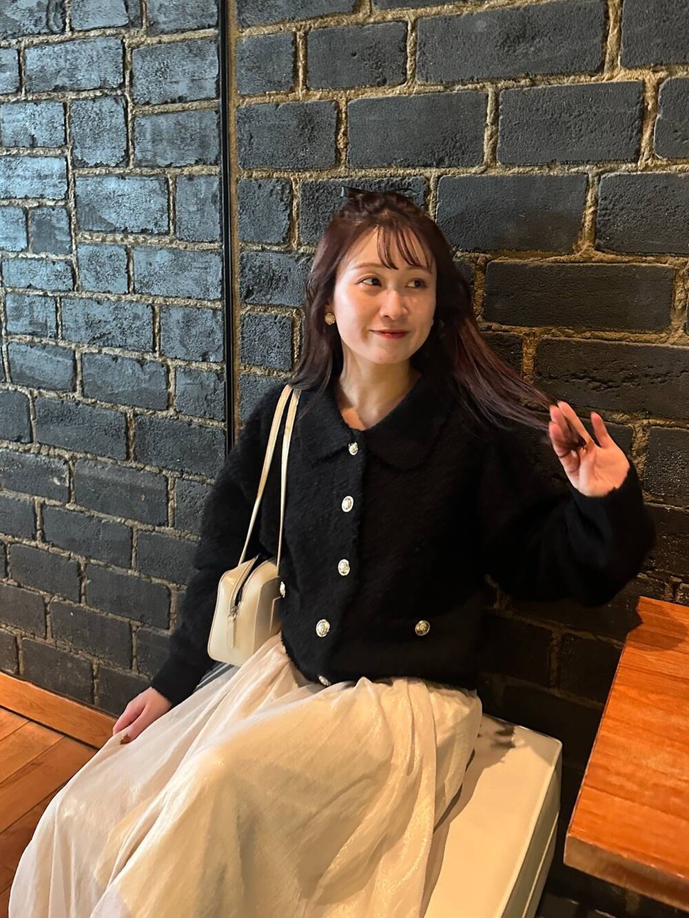 ブラック系のカーディガン/ボレロ、ホワイト系のスカートを着用したレディースの秋コーディネートの5枚目の写真