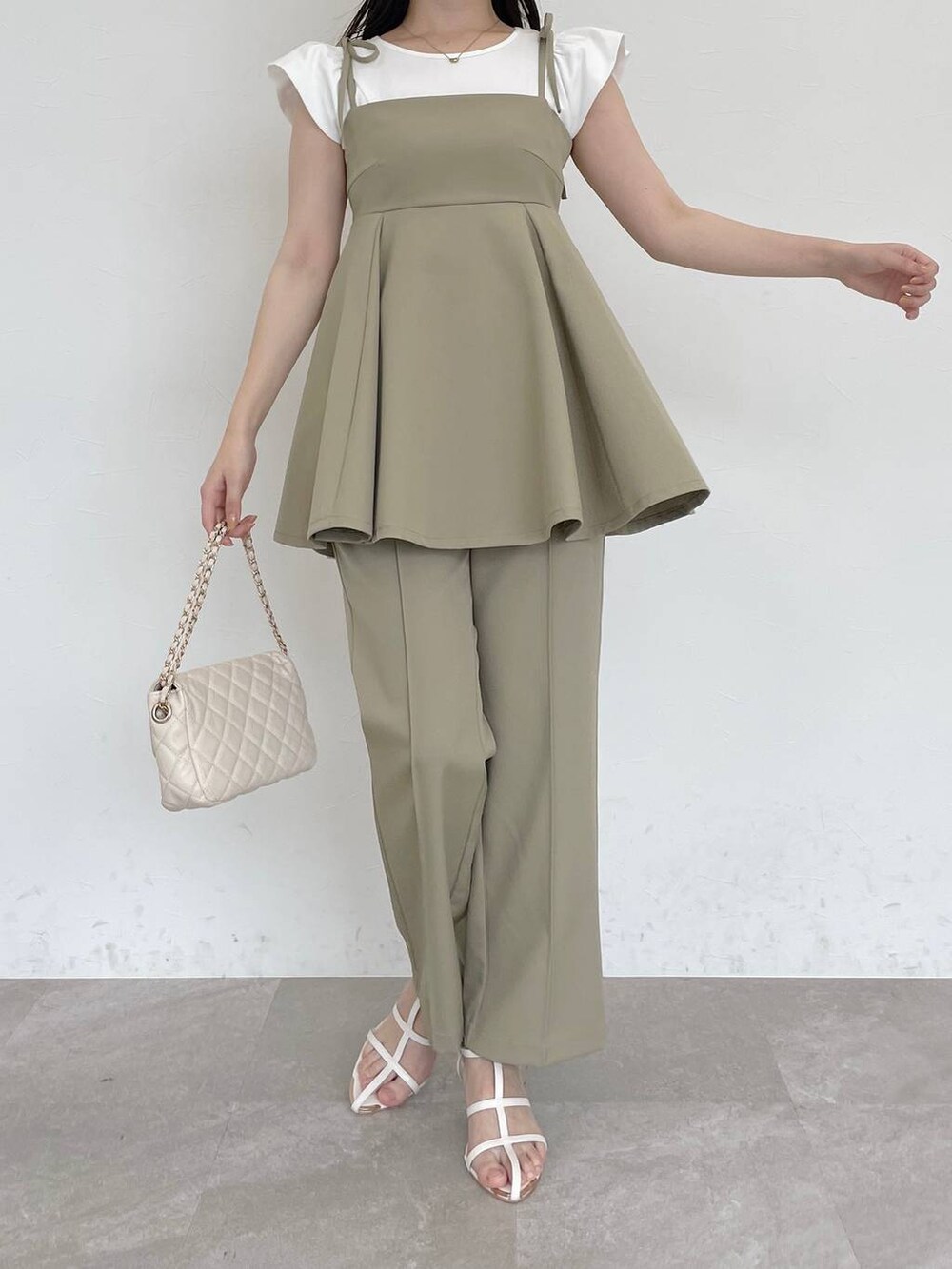 グリーン系のキャミソール、グリーン系のその他パンツ、ホワイト系のショルダーバッグを着用したレディースの春コーディネートの4枚目の写真