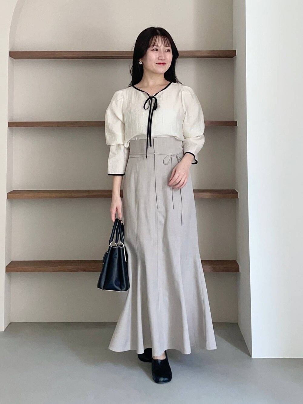 ブラック系のショルダーバッグ、ホワイト系のシャツ/ブラウス、ブラック系のパンプスを着用したレディースの冬コーディネートの3枚目の写真