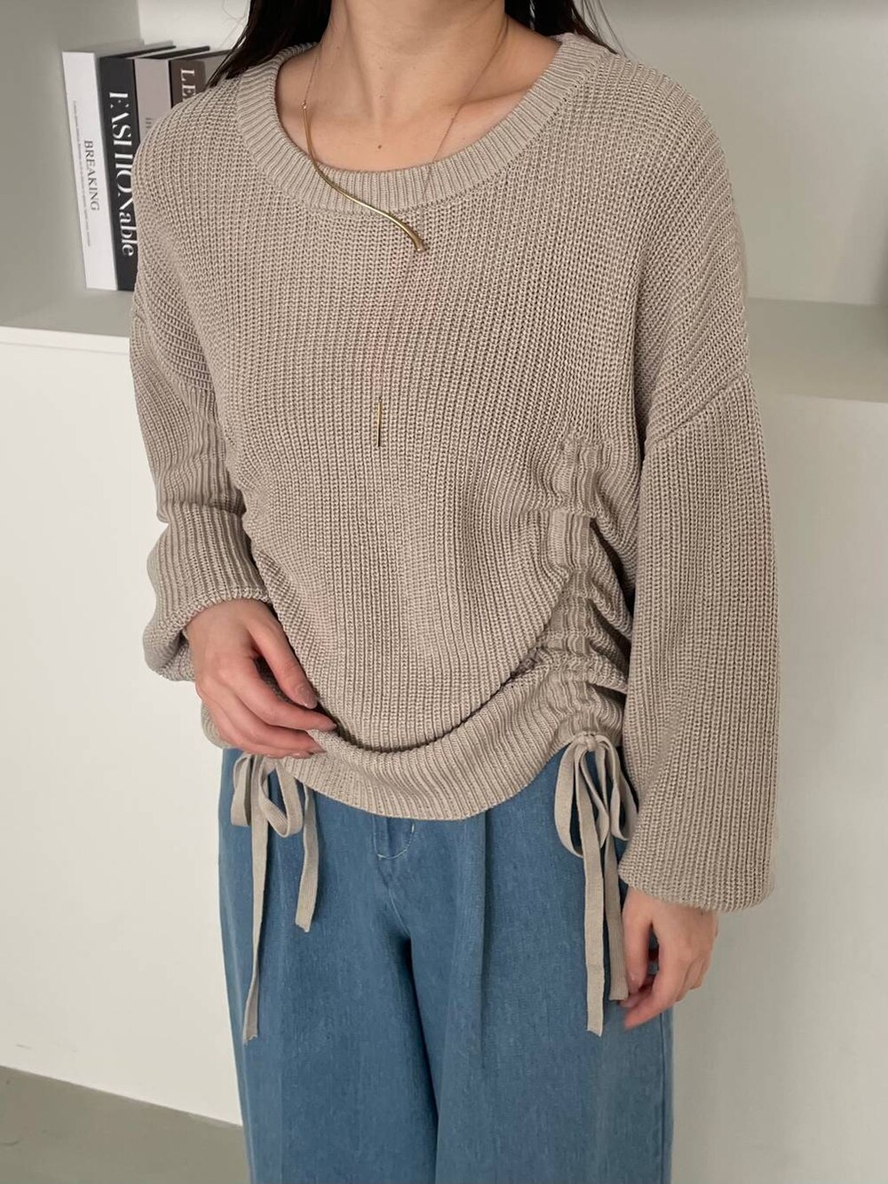 ベージュ系のショルダーバッグ、ブラウン系のパンプス、ブルー系のデニムパンツを着用したレディースの冬コーディネートの3枚目の写真