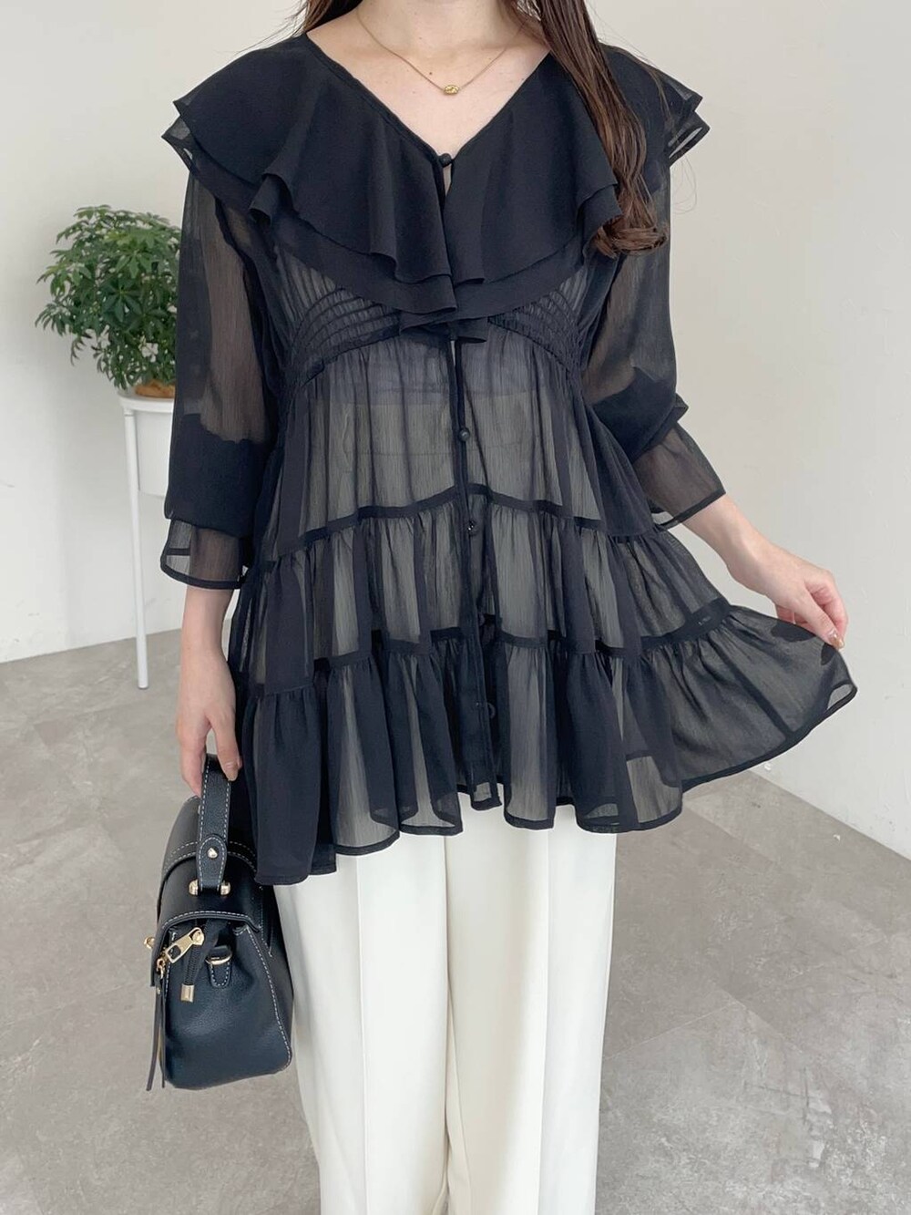 ブラック系のパンプス、ブラック系のショルダーバッグ、ブラック系のシャツ/ブラウスを着用したレディースの夏コーディネートの3枚目の写真