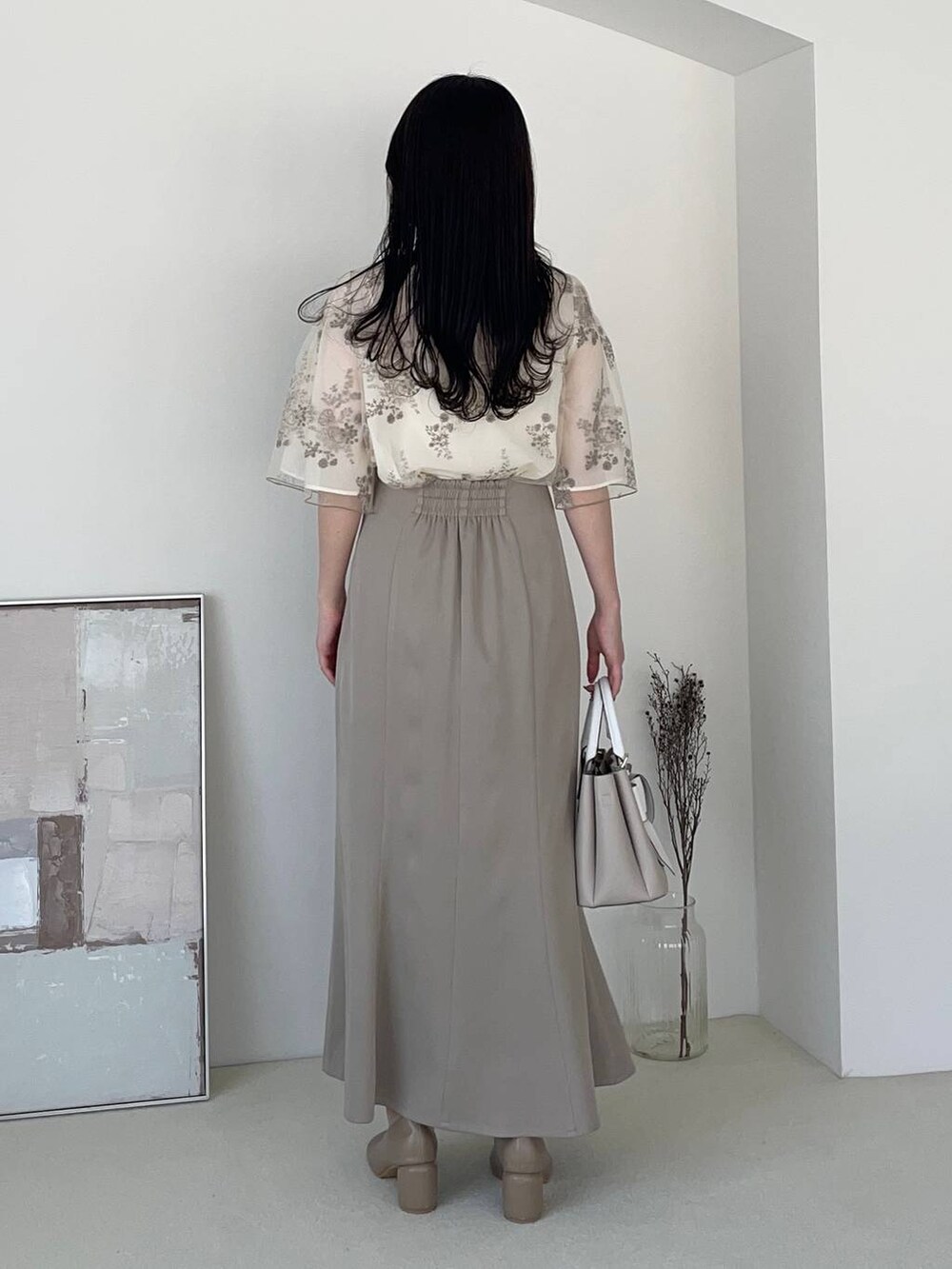 ベージュ系のショルダーバッグ、ブラウン系のパンプス、ホワイト系のシャツ/ブラウスを着用したレディースの夏コーディネートの2枚目の写真