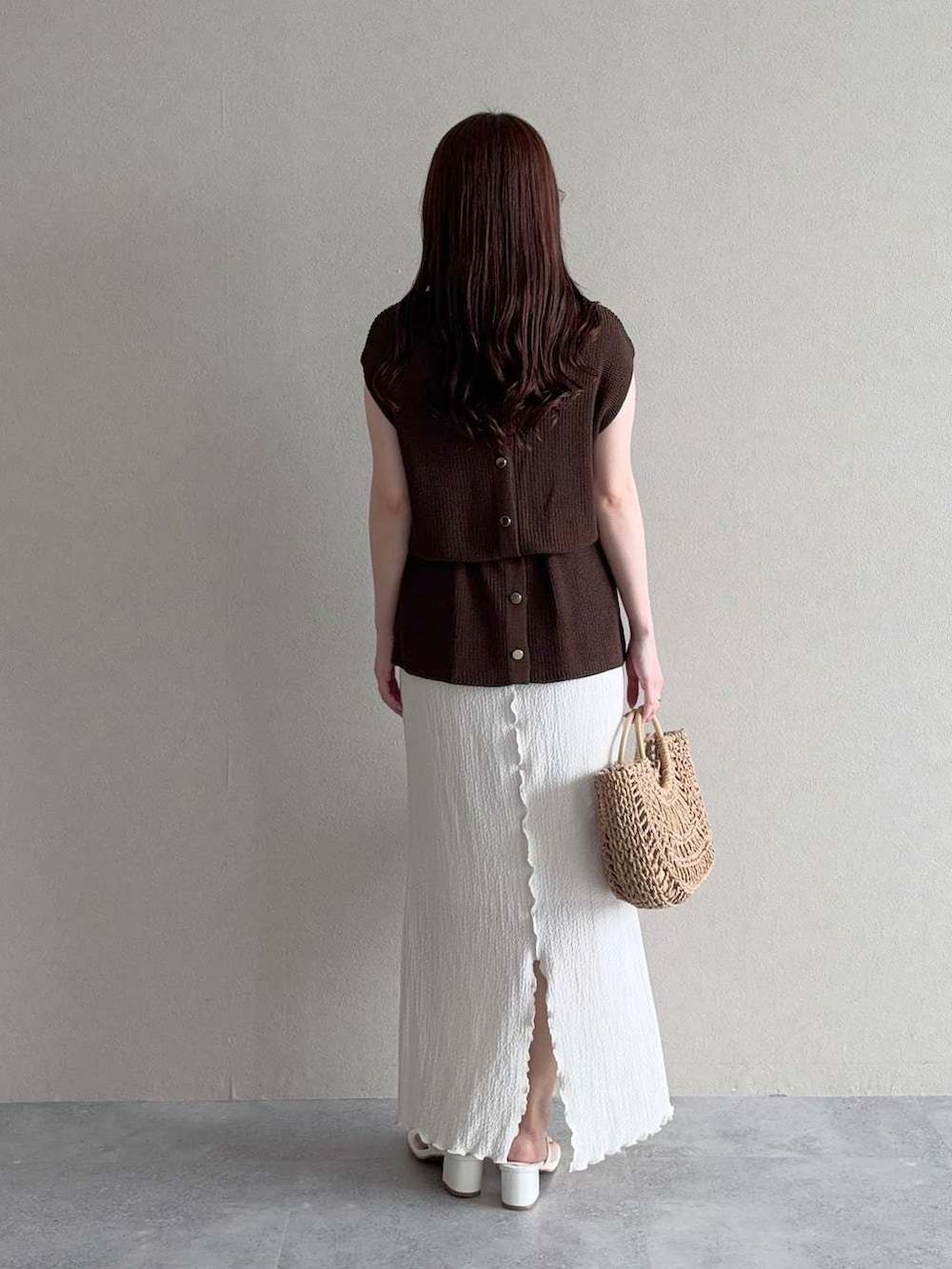 ホワイト系のスカート、ブラウン系のかごバッグを着用したレディースの夏コーディネートの2枚目の写真
