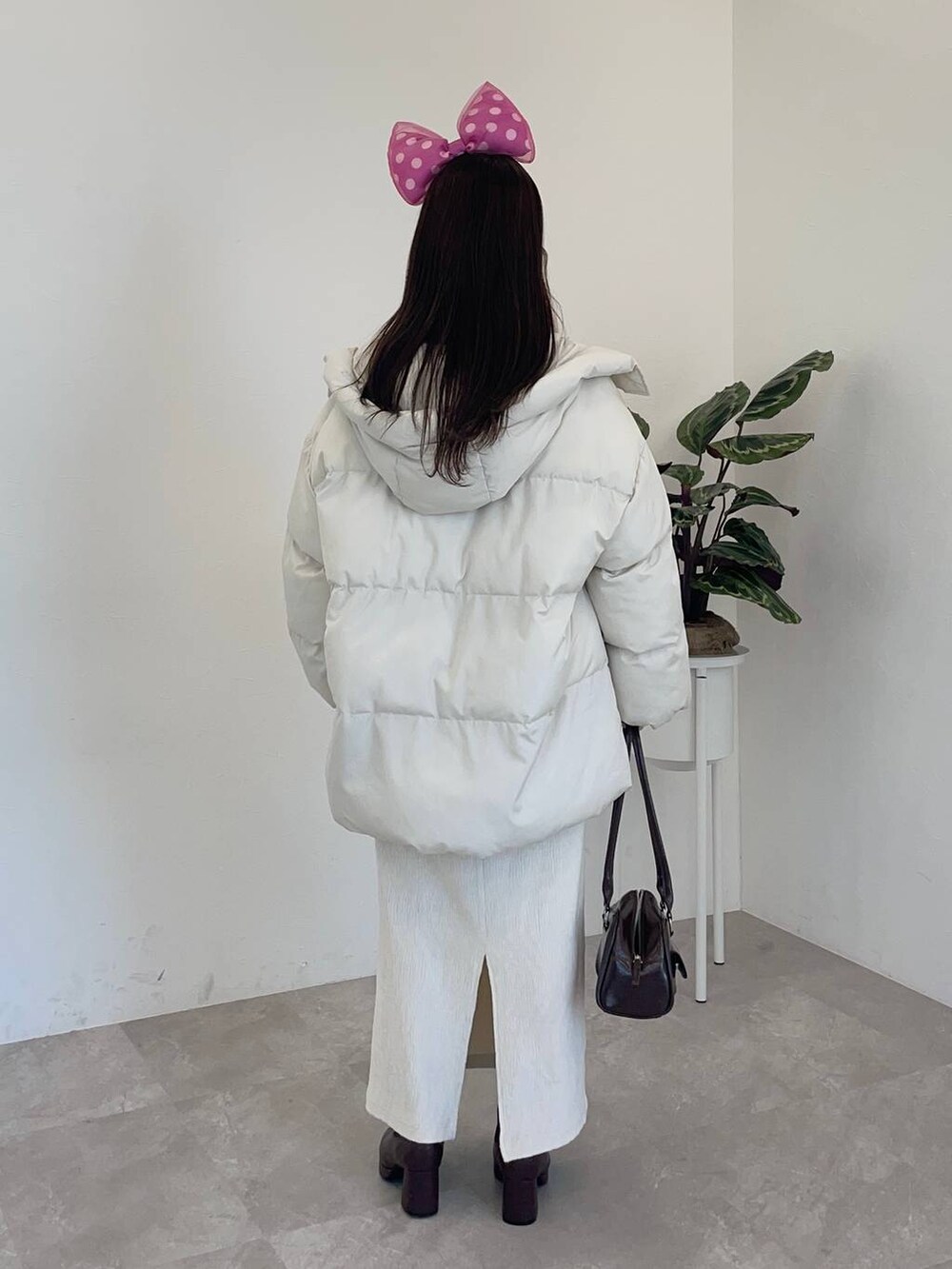 ブラウン系のブーツ、ホワイト系のスカート、ピンク系のニット/セーターを着用したレディースの冬コーディネートの2枚目の写真