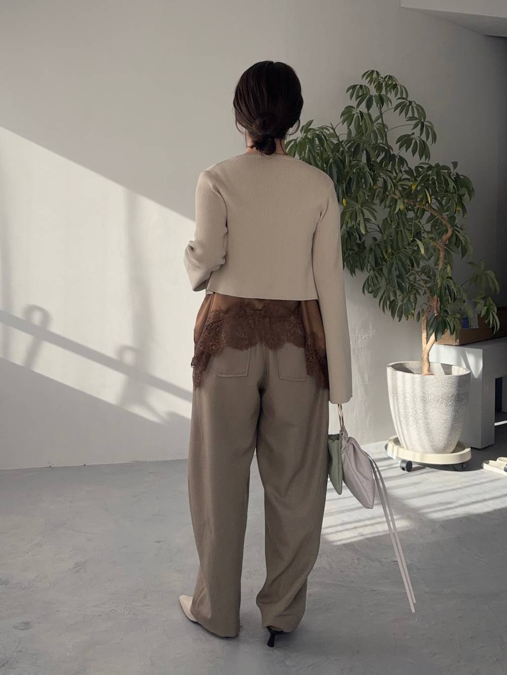 ホワイト系のサンダル、ベージュ系のその他パンツ、ブラウン系のキャミソールを着用したレディースの冬コーディネートの2枚目の写真