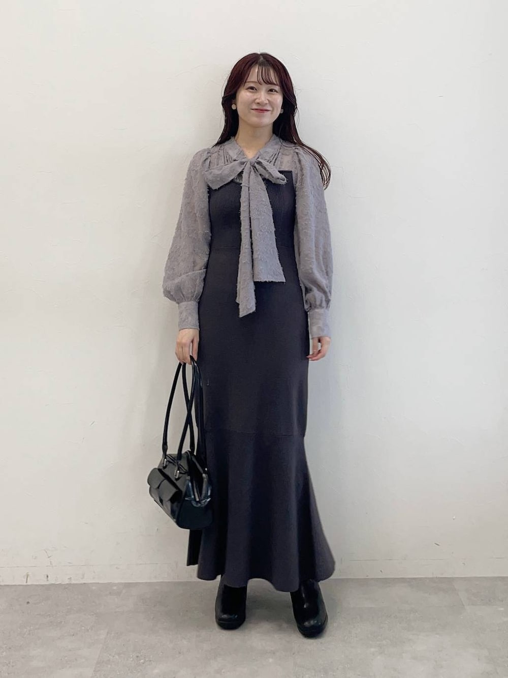 ホワイト系のブルゾン、ブラック系のブーツ、グレー系のワンピースを着用したレディースの秋コーディネートの5枚目の写真