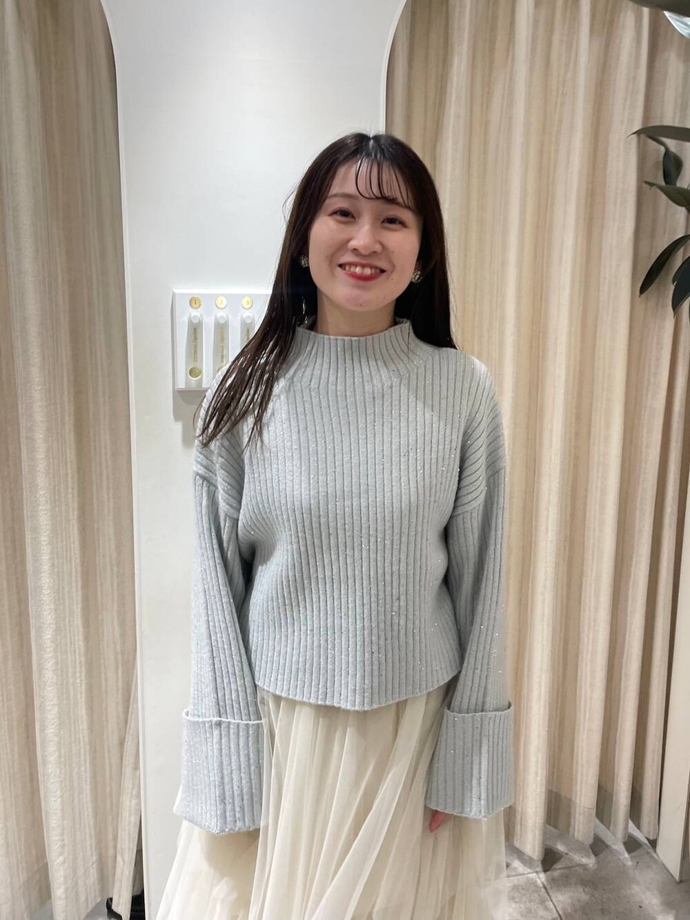 ブラック系のブーツ、ブルー系のニット/セーター、ホワイト系のスカートを着用したレディースの冬コーディネートの4枚目の写真