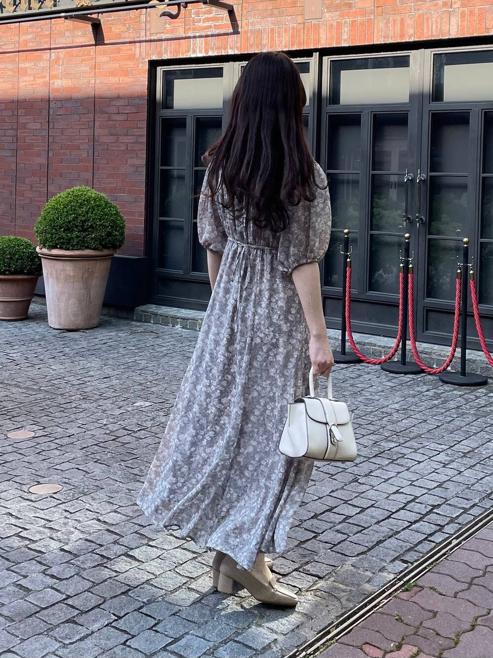グレー系のワンピースを着用したレディースの夏コーディネートの2枚目の写真