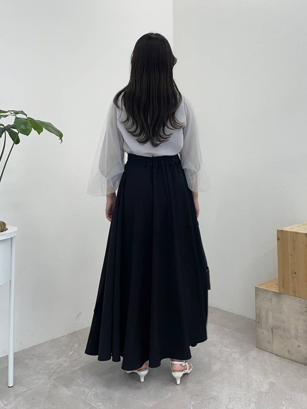 ブラック系のショルダーバッグ、ホワイト系のサンダル、ブルー系のTシャツ/カットソーを着用したレディースの夏コーディネートの2枚目の写真