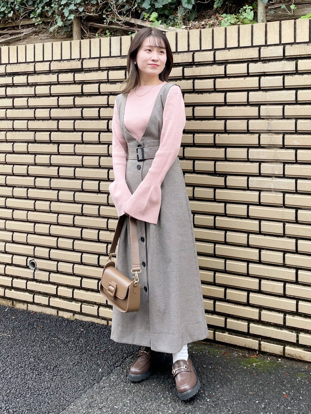 ブラウン系のテーラードジャケット、ピンク系のニット/セーター、ブラウン系のショルダーバッグを着用したレディースの冬コーディネートの5枚目の写真