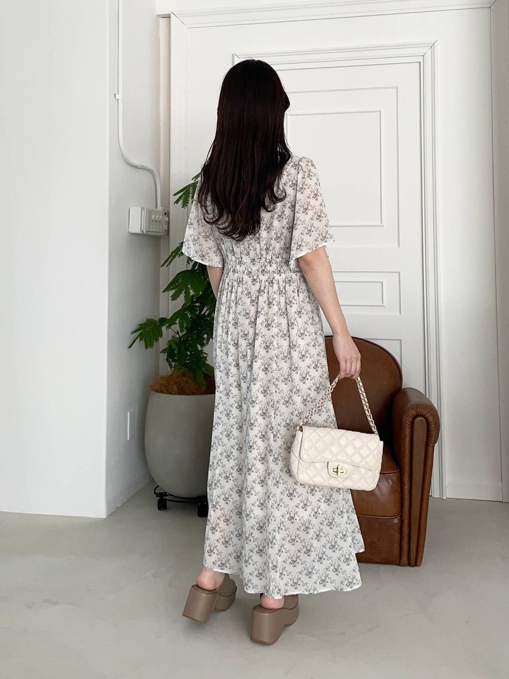 ベージュ系のサンダル、ホワイト系のショルダーバッグ、ホワイト系のワンピースを着用したレディースの夏コーディネートの2枚目の写真