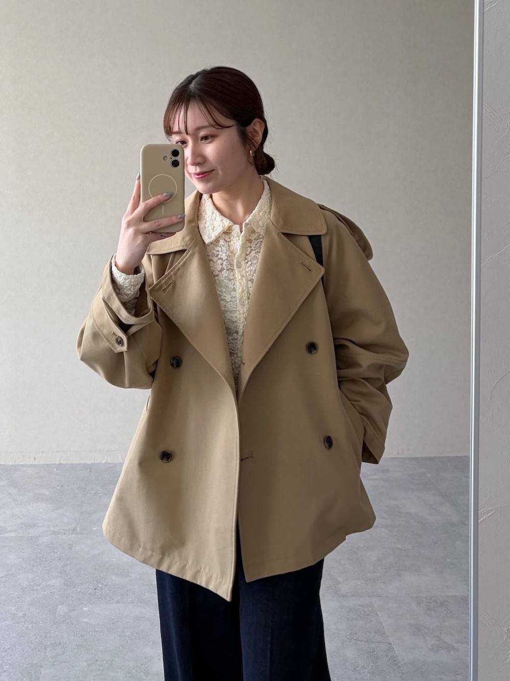 ベージュ系のトレンチコート、ブラック系のサンダル、ブルー系のデニムパンツを着用したレディースの冬コーディネートの3枚目の写真