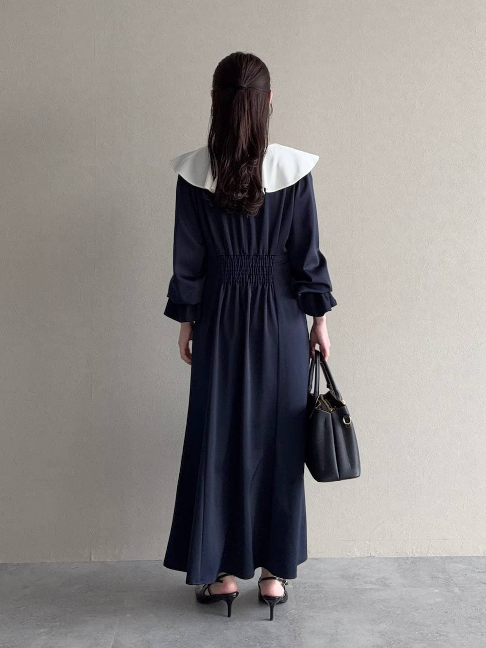 ブラック系のサンダル、ブルー系のワンピースを着用したレディースの春コーディネートの2枚目の写真