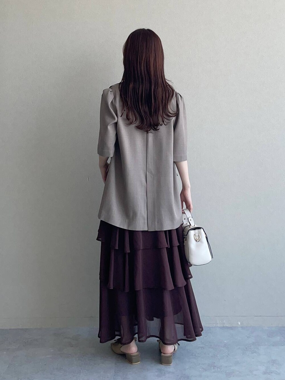 ブラウン系のサンダル、ホワイト系のショルダーバッグ、ブラウン系のワンピースを着用したレディースの夏コーディネートの2枚目の写真