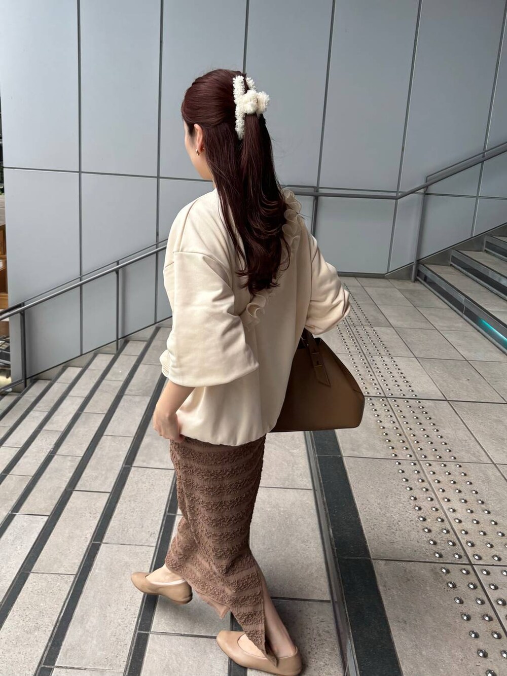 ホワイト系のスウェット、ブラウン系のスカート、ホワイト系のスマホグッズを着用したレディースの秋コーディネートの4枚目の写真