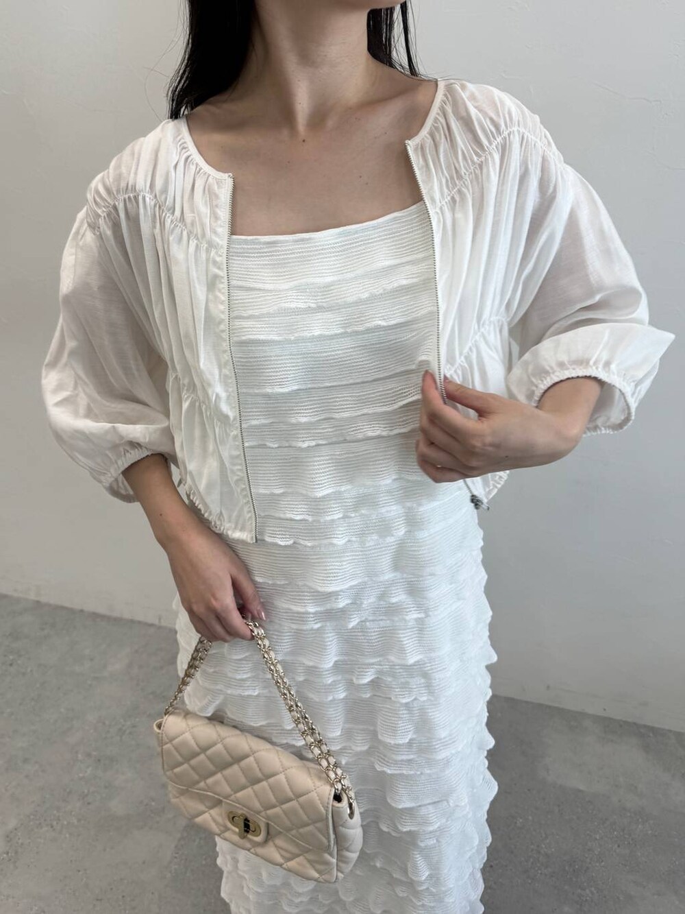 ホワイト系のブルゾン、ホワイト系のワンピース、ホワイト系のショルダーバッグを着用したレディースの夏コーディネートの3枚目の写真